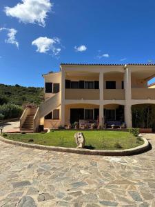a dog sitting in the grass in front of a building at Elena's apartment in Cannigione