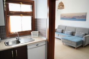 eine Küche mit einem Waschbecken und einem Sofa in einem Zimmer in der Unterkunft CASA VELA by Mhousing in Playa Blanca