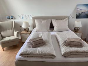 een wit bed met handdoeken erop in een slaapkamer bij Hausboot Maritim Holiday in Großenbrode