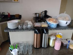 a kitchen with a counter with glasses and a coffee maker at Hotel e Pousada dos Leões in São Luís