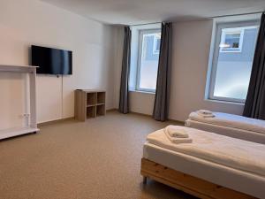 a hotel room with two beds and a flat screen tv at T&K Apartments - Herne - comfortable 1-3 room apartments in Herne