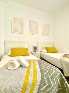 een slaapkamer met twee bedden met handdoeken erop bij Casa Jabega By Solymar Holiday in Torre del Mar