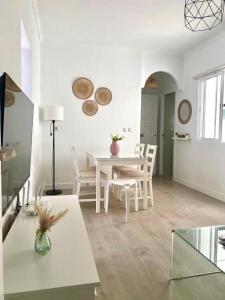 een witte woonkamer met een tafel en stoelen bij Casa Jabega By Solymar Holiday in Torre del Mar