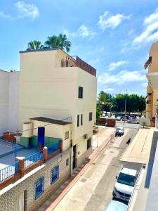 een wit gebouw met auto's ervoor geparkeerd bij Casa Jabega By Solymar Holiday in Torre del Mar +25 foto's