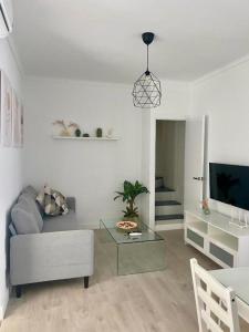 een woonkamer met een bank en een tafel bij Casa Jabega By Solymar Holiday in Torre del Mar