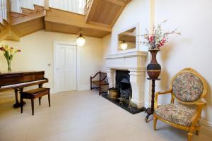 a living room with a piano and a fireplace at St Columbs House in Buncrana