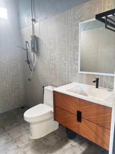 une salle de bain avec toilettes, lavabo et miroir dans l'établissement Chom Nakhon Resort, à Tha Sala