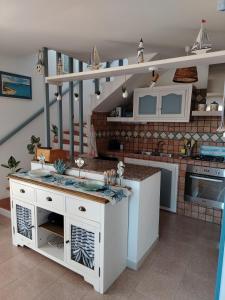 a kitchen with white cabinets and a counter top at La Finestra Sul Mare in Stintino