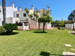 a yard in front of a white house at Casa Segovia By Solymar Holiday in Caleta De Velez