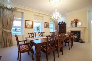 a dining room with a table and chairs and a fireplace at St Columbs House in Buncrana