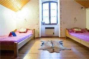 a bedroom with two beds and a rug on the floor at Gîte de poujols in Mas Saint-Chély