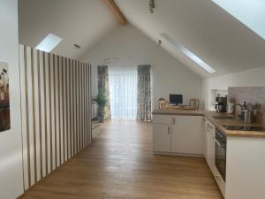 a kitchen with white walls and a wooden floor at Untersberg Appartement 2 in Grödig