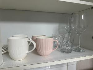 a shelf with cups and wine glasses on it at Stay Cozy Corner Gangnam, Suseo, Ilwon-dong, Samsung Hospital, a 7-minute walk from Daecheong Statio in Seoul +3 photos