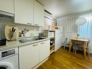 a kitchen with white cabinets and a table at Stay Cozy Corner Gangnam, Suseo, Ilwon-dong, Samsung Hospital, a 7-minute walk from Daecheong Statio in Seoul