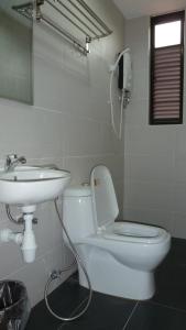 y baño con aseo blanco y lavamanos. en Hotel Hong en Melaka