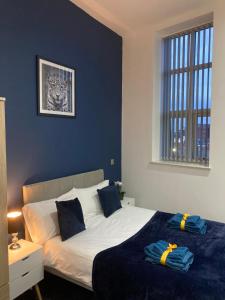 a bedroom with a large bed with blue walls at Central Doncaster 1BED 1BATH Pent-Apartment in Doncaster