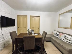a dining room with a table and a couch at Barkada Getaway Near Esplanade in Iloilo City