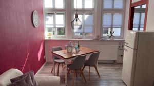 a kitchen with a table and chairs and a refrigerator at Altstadt Fewo Wernigerode in Wernigerode