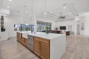 a kitchen with a white counter top and a living room at SAN3337 Canalfront Vacation Pool Home in Punta Gorda