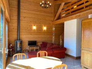 a living room with a red couch and a tv at Chalet Pip - Modern chalet with breathtaking views in Morzine