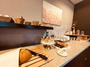 a kitchen with a counter with bread and other foods at Hotel Rooms in Breskens