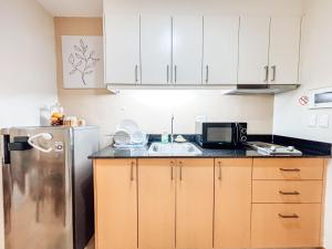 a kitchen with a sink and a refrigerator at Your Luxury Studio Escape in Iloilo City