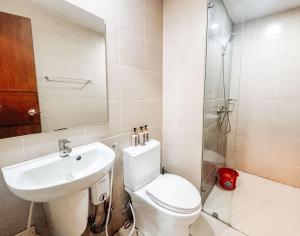 a bathroom with a toilet and a sink and a shower at Your Luxury Studio Escape in Iloilo City +8 photos