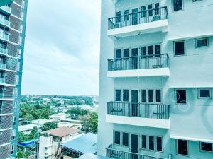 a tall white building with balconies and a city at Your Luxury Studio Escape in Iloilo City