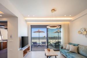 a living room with a couch and a table with chairs at Four Horizons Luxury Villas in Kournás