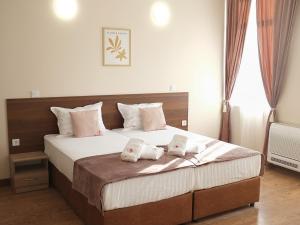a bedroom with a large bed with two pillows on it at Self Check-in Семеен Хотел Рудин in Stara Zagora