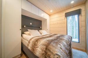 Un dormitorio con una cama grande y una ventana. en Villa Chill Levi, en Kittilä