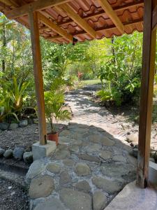 a stone walkway under a wooden pergola at Casa Cielo in Pavones +6 photos