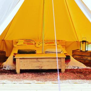 HemyockLickham Bottom Camping的黄色帐篷,里面设有一张床