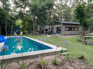 a house with a swimming pool in a yard at Descanso en el Bosque in Brandsen