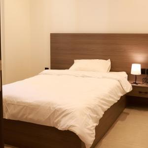 a bedroom with a large white bed with a wooden headboard at BHomed Shaab in Kuwait +43 photos