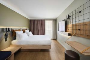 a hotel room with a bed and a window at Moxy Annecy in Annecy