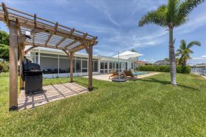 a backyard with a pergola and a grill at MAD510 Punta Gorda Isles in Punta Gorda