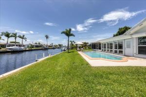 a house with a swimming pool next to a body of water at MAD510 Punta Gorda Isles in Punta Gorda
