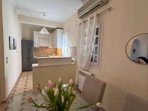 a kitchen with white cabinets and a vase of flowers at Athinas House in Corfu Town