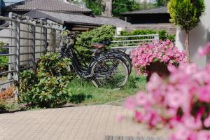 a bike parked next to a fence with pink flowers at Hotel Aqua Sopot - Destigo Hotels in Sopot