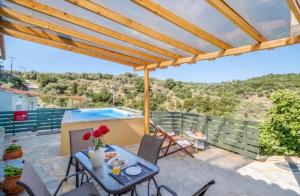 梅加尼西岛Villa Μyrtali的一个带桌椅的露台和一个游泳池