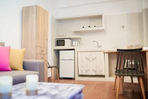 a living room with a couch and a kitchen at OFIOYSA KaGa kythnosuites in Mérikhas