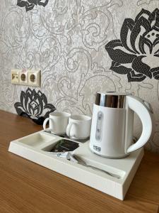 a coffee maker on a tray with two cups on it at Готель ПАРК in Morshin