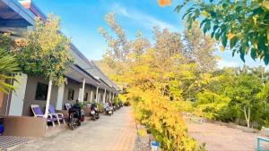 a building with chairs and trees next to a sidewalk at ที่พักบ้านเก๋ เกาะล้าน in Ko Larn