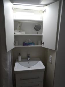 a bathroom with a sink and a light above it at Ferienwohnung am Pilsensee in Seefeld +26 photos