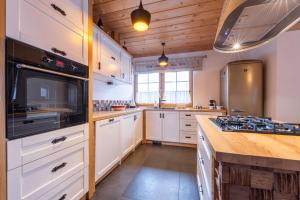 a kitchen with white cabinets and a stove top oven at Willa wakacyjna "Willa Kosibówka" z widokiem na góry dla 12 osób, sauna in Bukowina Tatrzańska