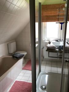 a bathroom with a tub and a sink at Christiansand in Norddorf +16 photos