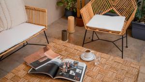 two chairs and a table with a book and a cup of coffee at otel alba Alaçatı in Cesme