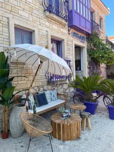 a patio with a bench and a table and an umbrella at otel alba Alaçatı in Cesme