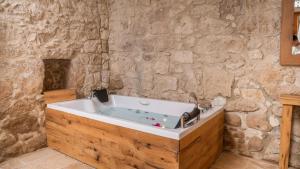 a bath tub in a room with a stone wall at otel alba Alaçatı in Cesme +11 photos